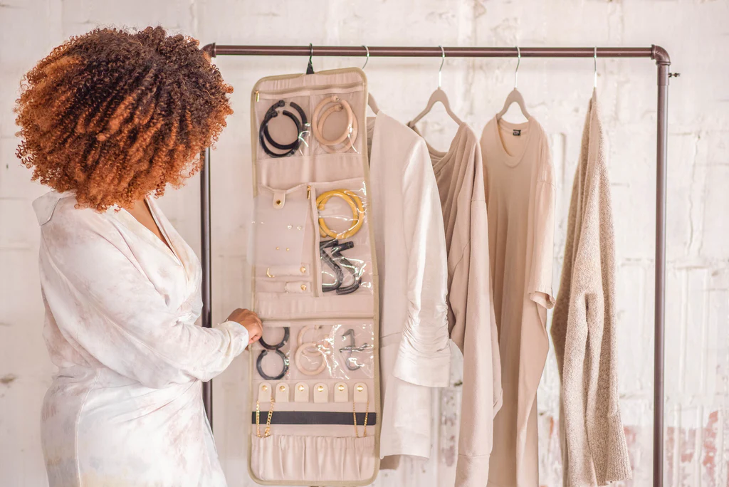 Transparent hanging jewelry organizer displaying earrings and bracelets.