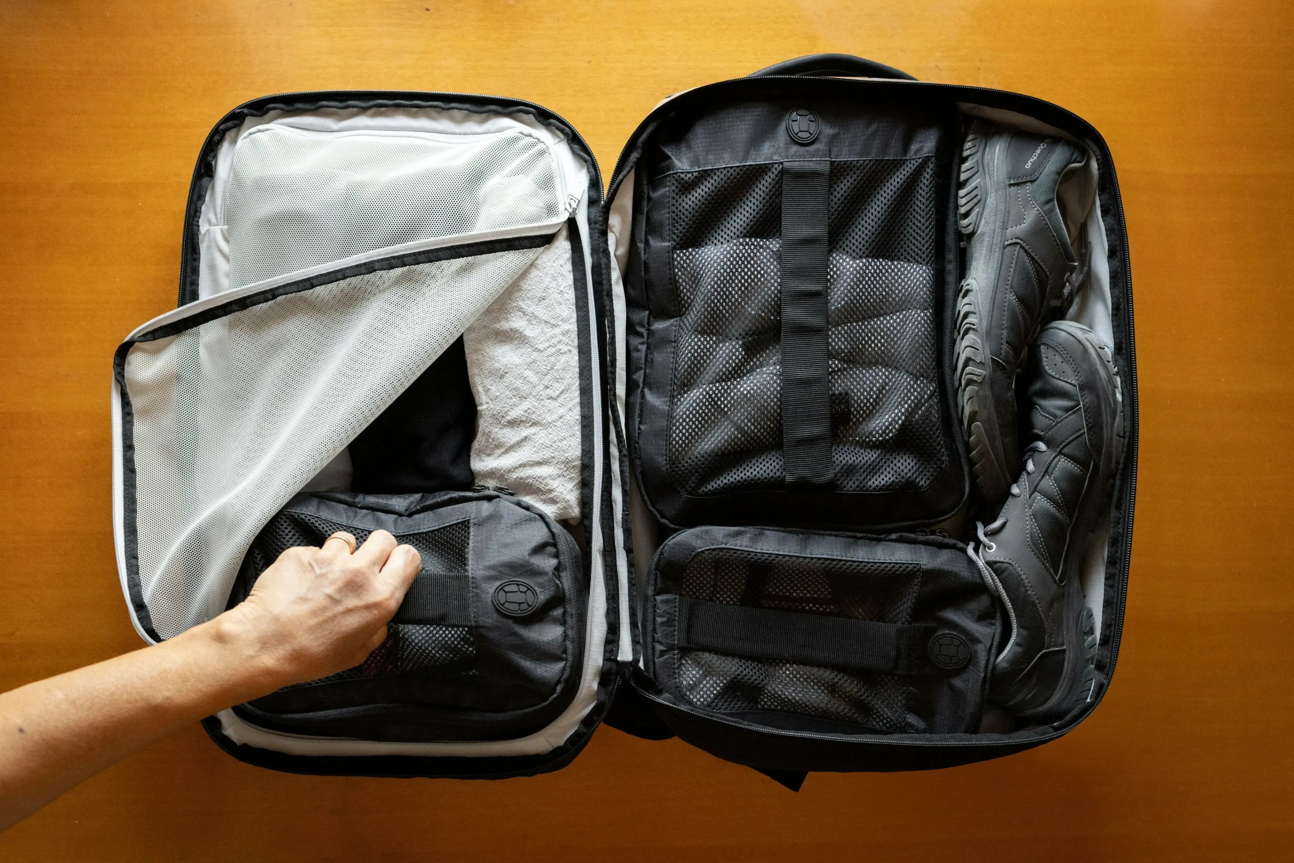 Compact travel laundry bag folded and placed on top of packing cubes