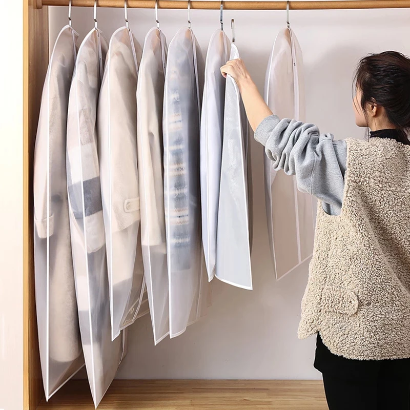 Hanging clothes protected in garment bags on a rolling rack ready for storage unit