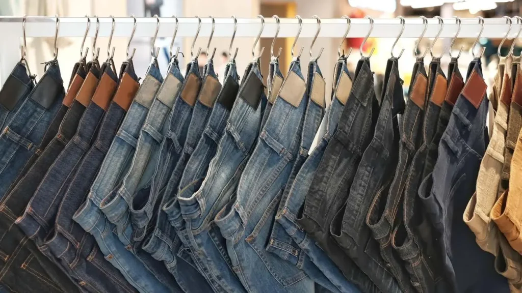Multi-layered hanger organizing different colored jeans inside a closet