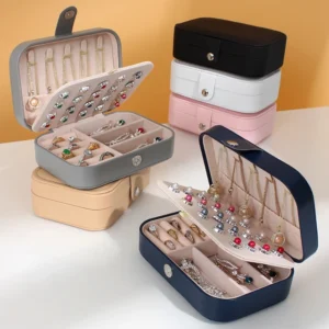 Multiple styles of travel jewelry organizer boxes displayed near open luggage