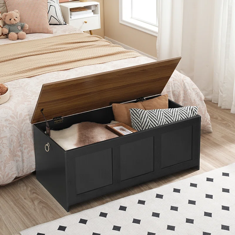 Wooden bedroom bench with flip-top storage filled with folded sweaters