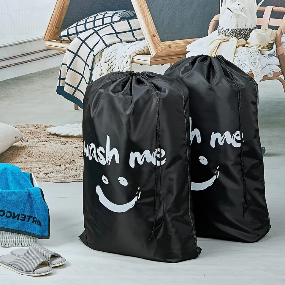 Drawstring dirty clothes travel bag placed next to an open suitcase