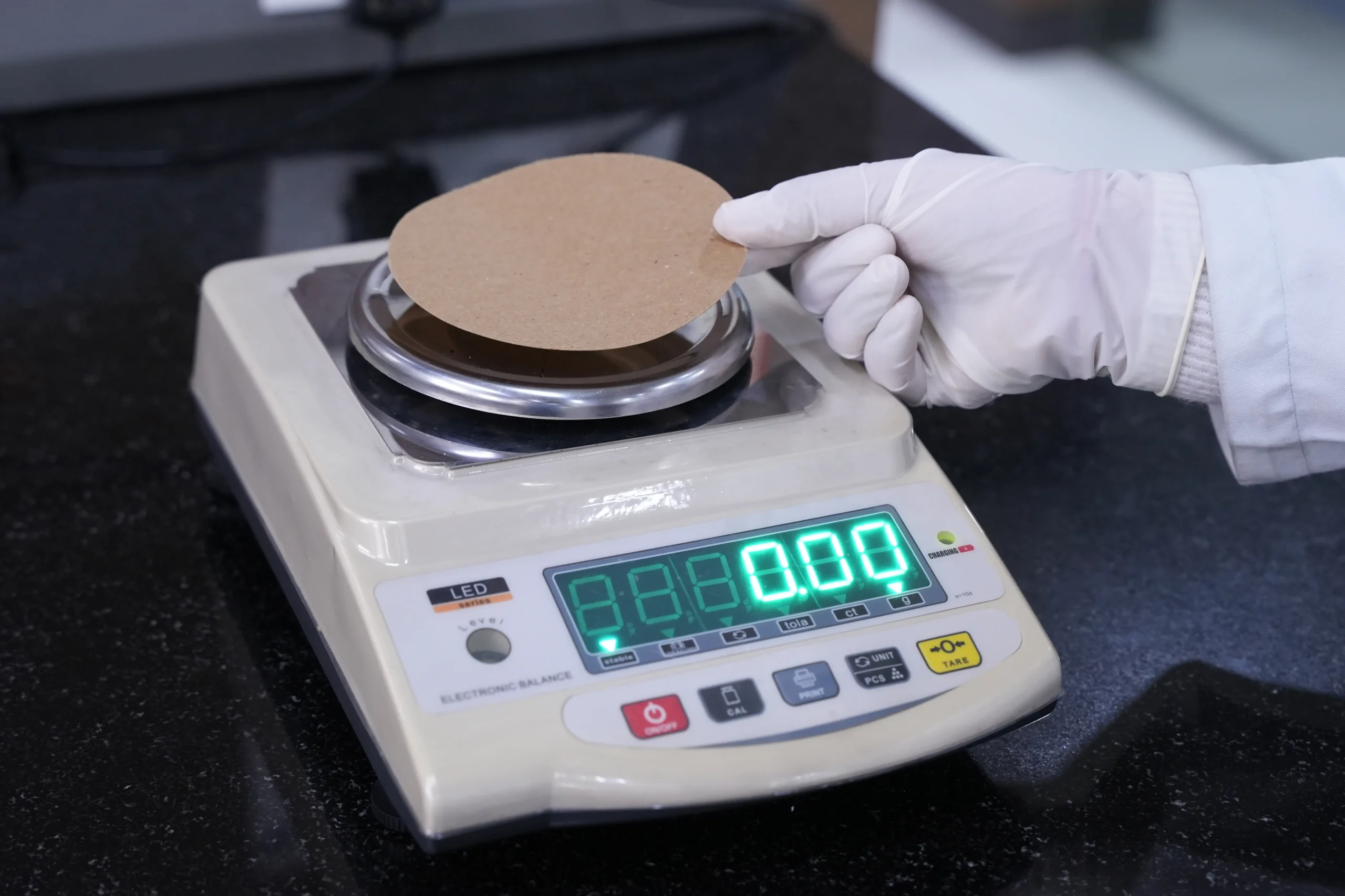 Fabric sample being weighed on digital scale to calculate GSM