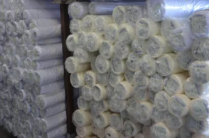 Rolls of chiffon fabric in multiple colors displayed in fabric shop