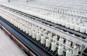 Industrial spinning machine converting raw fibers into yarn for fabric production