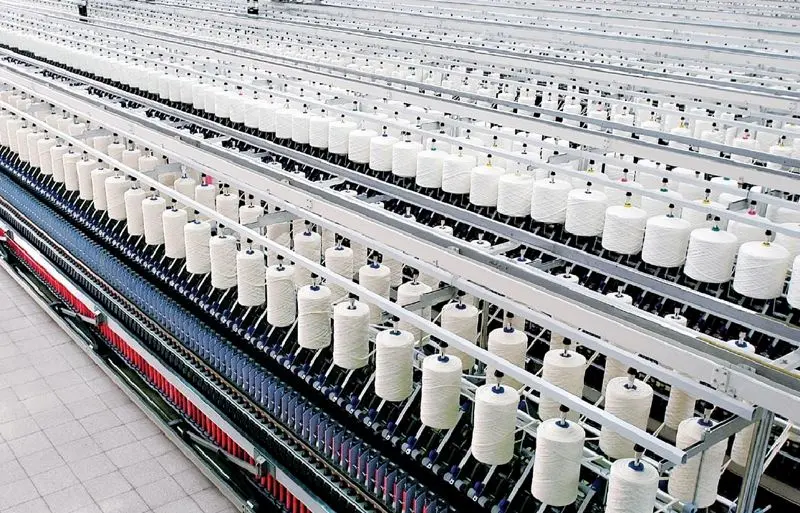 Industrial spinning machine converting raw fibers into yarn for fabric production