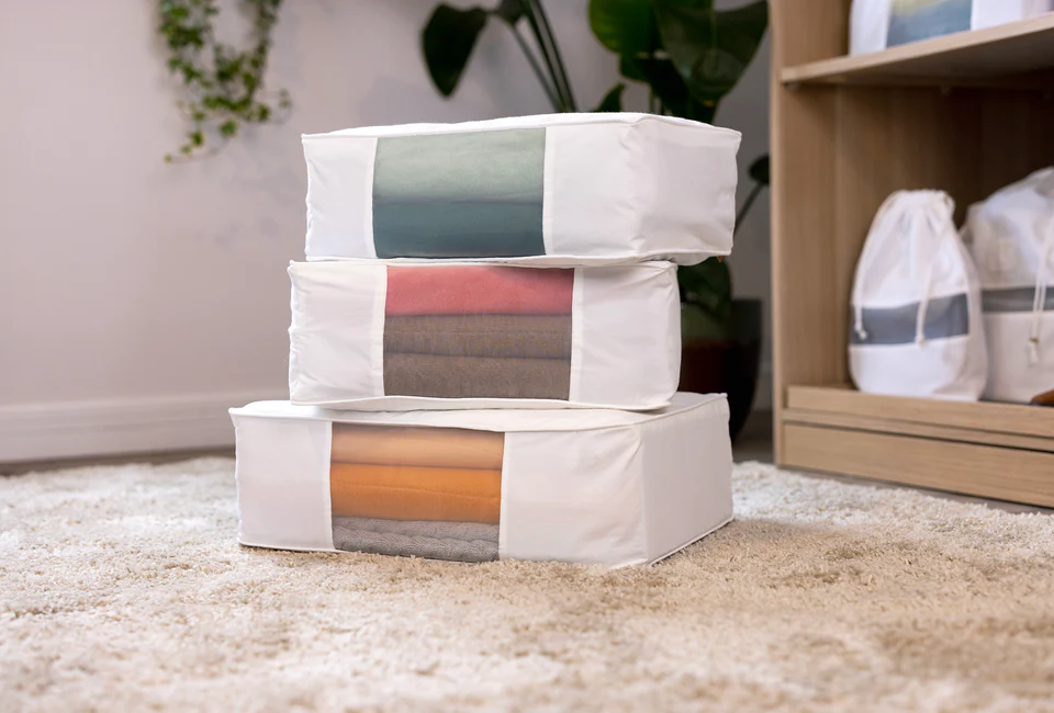 Multiple blanket storage bags stacked for seasonal bedding organization